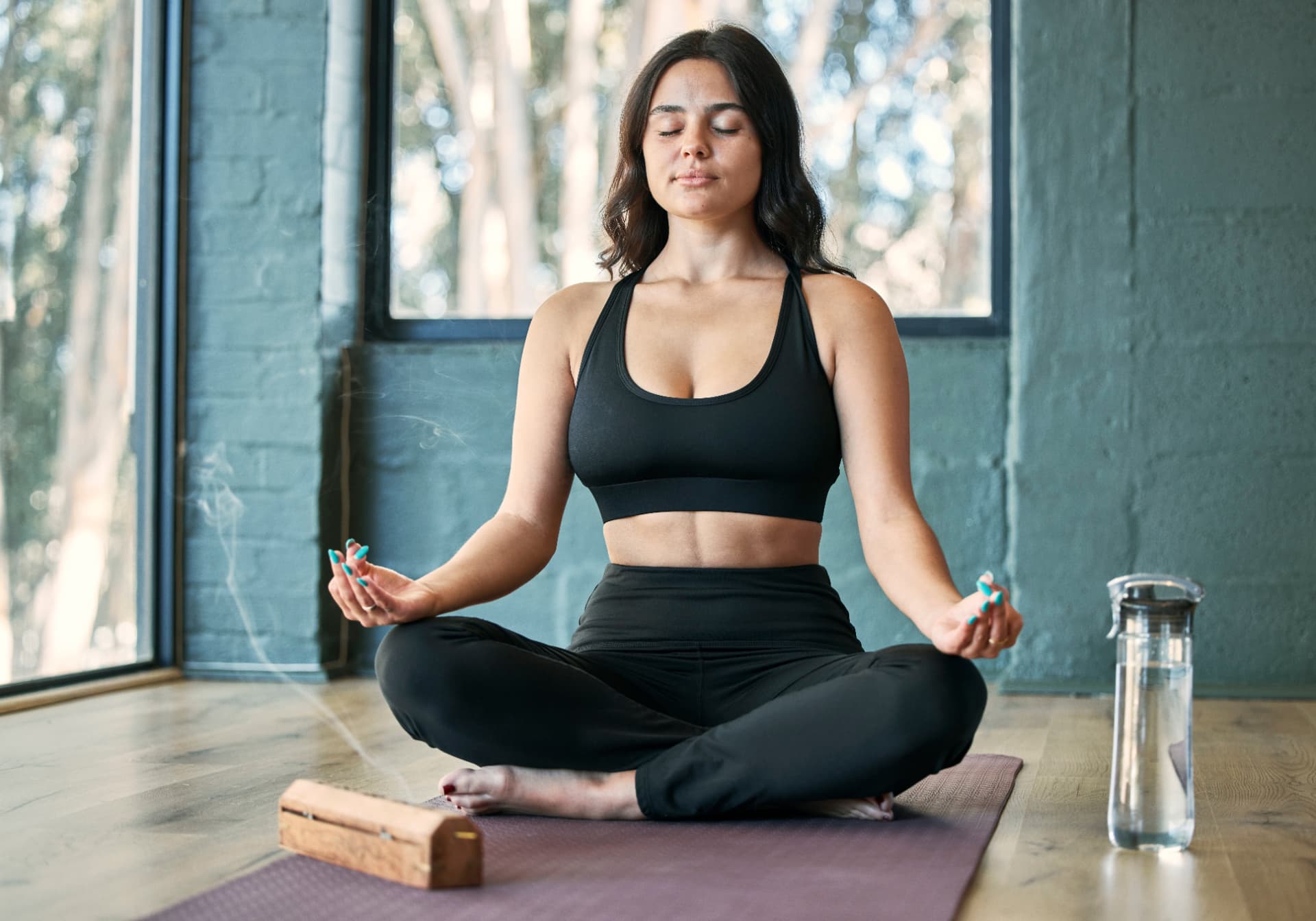 Woman meditating calmly on a yoga mat